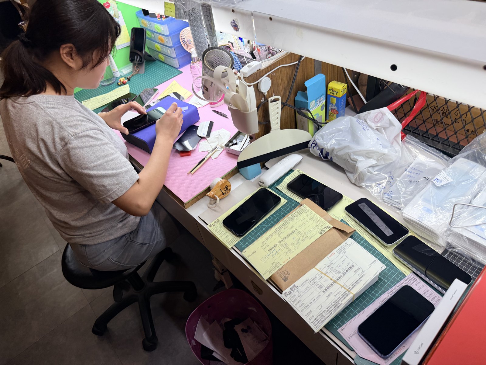 工作檯上的新機與施工工具；除了選產品，安裝細節也是整套保護的一部分。